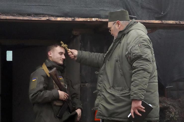 כומר מברך לוחם אוקראיני באזור חרקוב לרגל חג המולד אוקראינה מלחמה מול רוסיה