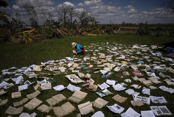 תמונות השנה 2022 מורה מייבשת ספרים ש נרטבו ב הוריקן איאן ב קובה