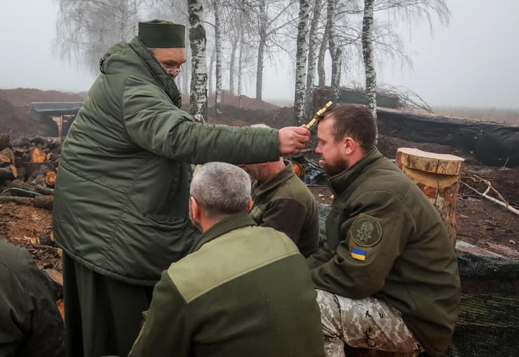 כומר מברך לוחם אוקראיני באזור חרקוב לרגל חג המולד אוקראינה מלחמה מול רוסיה
