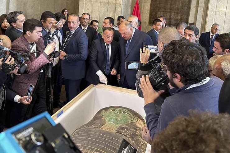 שר החוץ המצרי סאמח שוכרי (מימין) ומזכ"ל המועצה העליונה לענייני עתיקות של מצרים מוסטפא וואזירי, משוחחים מול סרקופג העץ העתיק במהלך טקס המסירה במשרד החוץ בקהיר