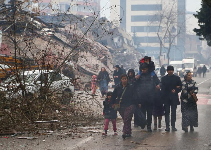 אנשים ליד הריסות הבניינים בעיר קרמאנמרש, טורקיה