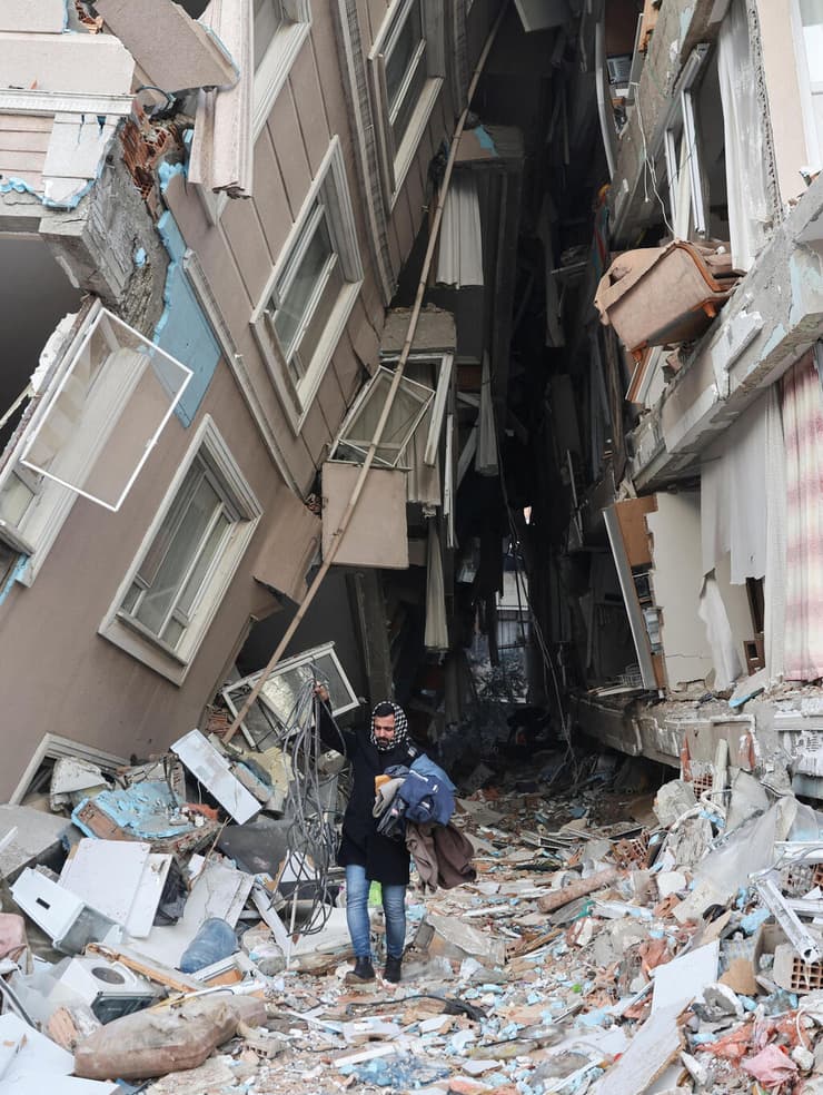 גבר שביתו נהרס מחלץ משם פריטים ב הטאי טורקיה רעידת אדמה רעש