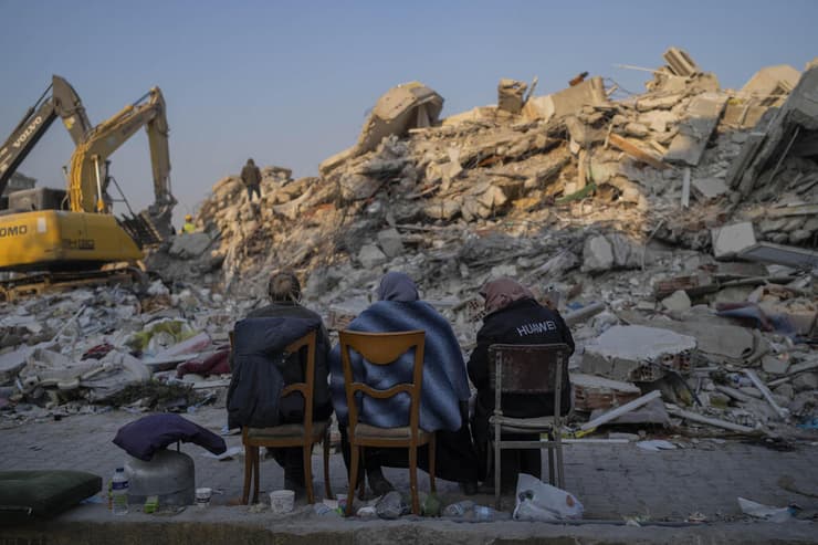 טורקיה נשים יושבות ומחכות ליד בית הרוס ב אדיאמאן רעידת אדמה