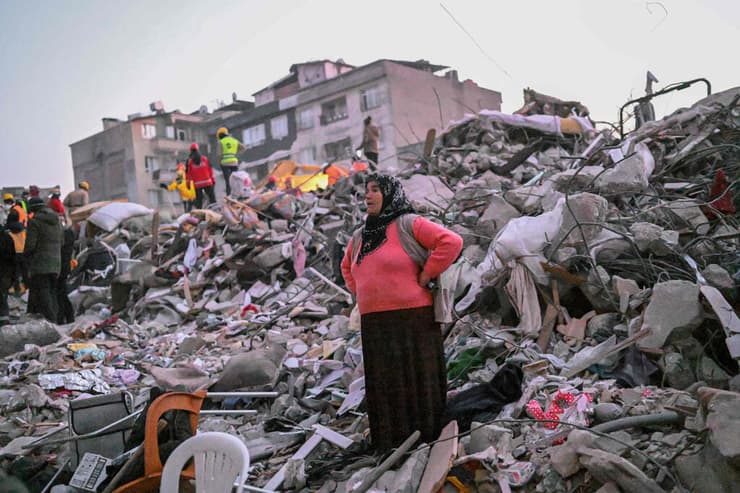 טורקיה אישה עומדת על הריסות מחוז הטאי בתקווה למצוא קרובי משפחה רעידת אדמה