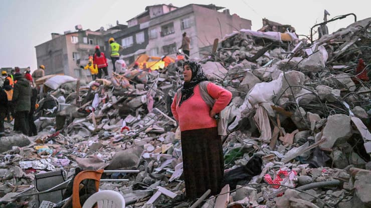טורקיה אישה עומדת על הריסות מחוז הטאי בתקווה למצוא קרובי משפחה רעידת אדמה