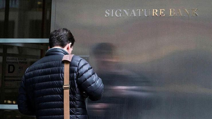אדם עומד מחוץ ל-signature bank