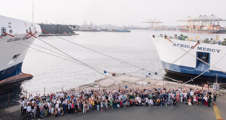 מאות מתנדבים מ-60 מדינות על רקע האוניה - אחי קושניר