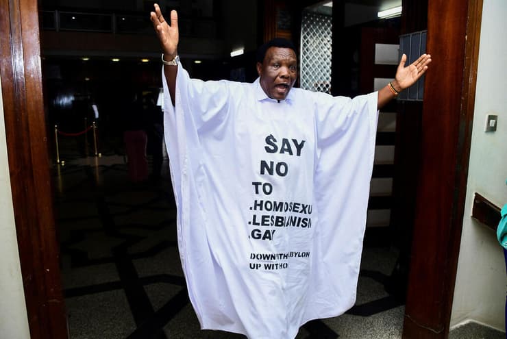 מחוקק ב אוגנדה שהגיע לדיון ב פרלמנט שבו אושר חוק נגד להט"ב ו הומוסקסואליות עם חולצה שליה נכתבה סיסמה בגנות להט"ב