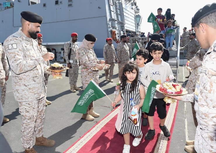 תושבים סעודים שחולצו מהקרבות ב סודן מתקבלים עם שוקולדים ופרחים בהגעתם לנמל ב ג'דה סעודיה