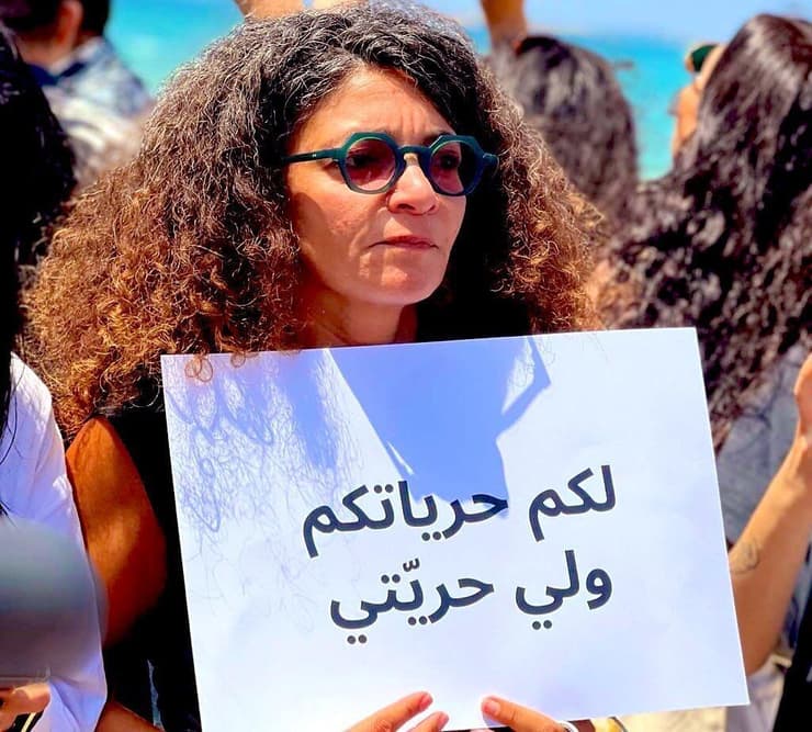 אישה מפגינה ב צידון לבנון בחוף בצל סערה אחרי שאישרה הוטרדה בגלל לבוש "לא-צנוע" על השלט שלה נכתב: לכם יש את החרויות שלכם, ולי יש את החרות שלי
