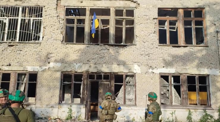 מניפים את דגל אוקראינה בכפר ששוחרר מכיבוש רוסי במחוז דונייצק