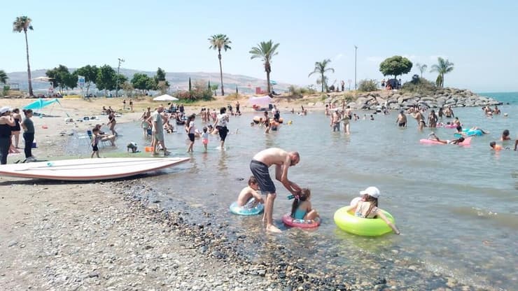 מטיילים מבלים בחוף צמח המחודש, בכינרת