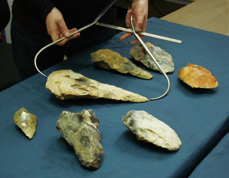 לטי אינגריי מודדת את גרזן היד הגדול ביותר שהתגלה בחפירות הארכיאולוגיות במחוז קנט
