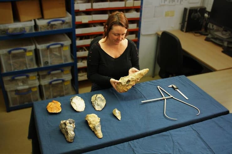 לטי אינגריי מודדת את גרזן היד הגדול ביותר שהתגלה בחפירות הארכיאולוגיות במחוז קנט