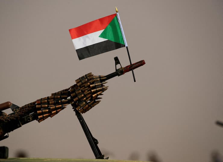 רובה על דגל סודן שמחזיק איש מיליציית RSF באזור חרטום יוני קרבות