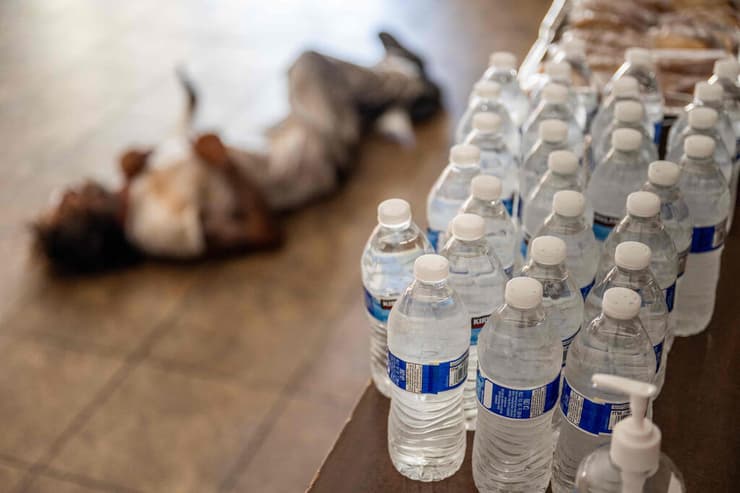 ארה"ב אריזונה פיניקס גל חום אדם נח על הרצפה במקלט שמפעילה כנסייה ליד ב קבוקי מים