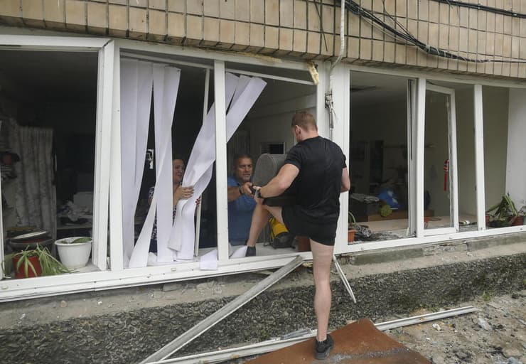 מוציאים רכוש מבית שנהרס וחלונותיו התנפצו במהלך המתקפה הלילית 