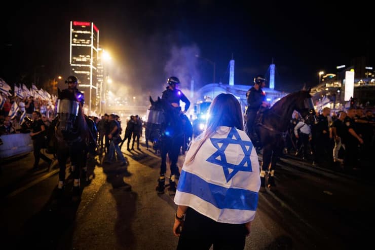 מפגינה מול פרשי משטרה במחאת מתנגדי המהפכה המשפטית בתל אביב, 20.7.2023