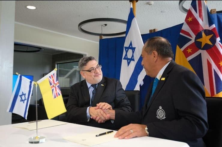  ראש ממשלת ניואה דלטון טאגלאגי חותם על המסמך עם רן יעקובי, שגריר ישראל לניו זילנד