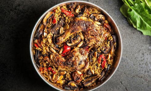 כרעיים בתנור עם יין, ירקות ובוטנים על מצע של פריקי