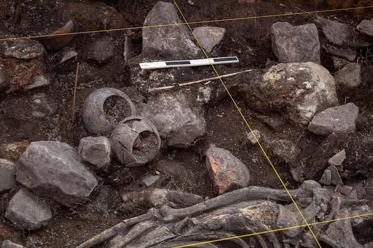 השלד והפריטים הקרמיים שנחשפו בקבר שהתגלה באתר הארכיאולוגי פאקופאמפה שבצפון פרו