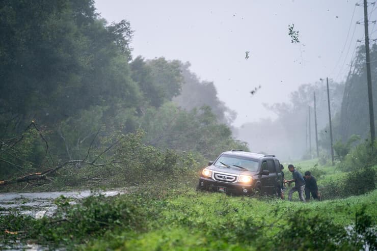 עצים מתעופפים ורכב שנתקע בגשם. מאיו, פלורידה 