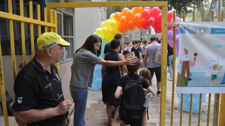 תלמידים ותלמידות בשער הכניסה לבית הספר גבריאלי בתל אביב