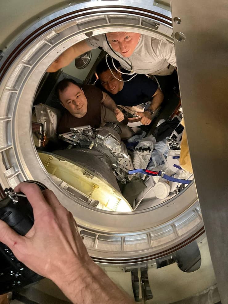שני הקוסמונאוטים והאסטרונואט נכנסים לסויוז בדרכם לכדור הארץ