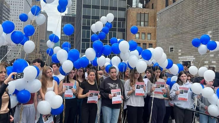 בני נוער יהודים מפריחים בלוני כחול לבן על גג הקונוסליה הישראלית  וקוראים להחזרת השבויים בניו יורק