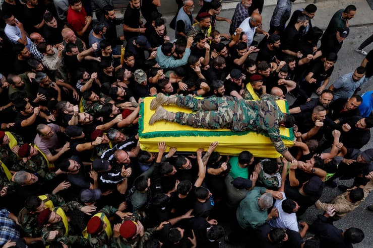 לבנון בנו של איש חיזבאללה שנהרג ב הפצצת צה"ל שוכב על ארונו ב הלוויה חרבות ברזל