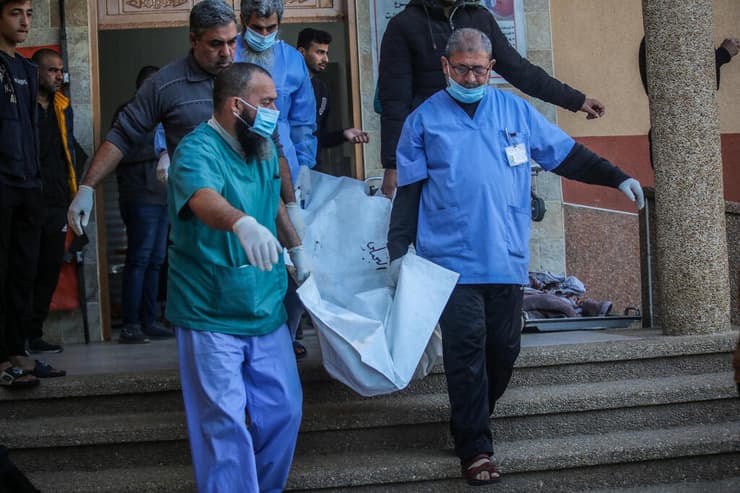 פלסטינים אוספים גופות של הרוגים ב חאן יונס רצועת עזה