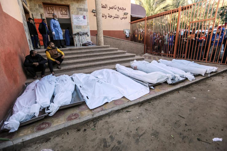 פלסטינים אוספים גופות של הרוגים ב חאן יונס רצועת עזה