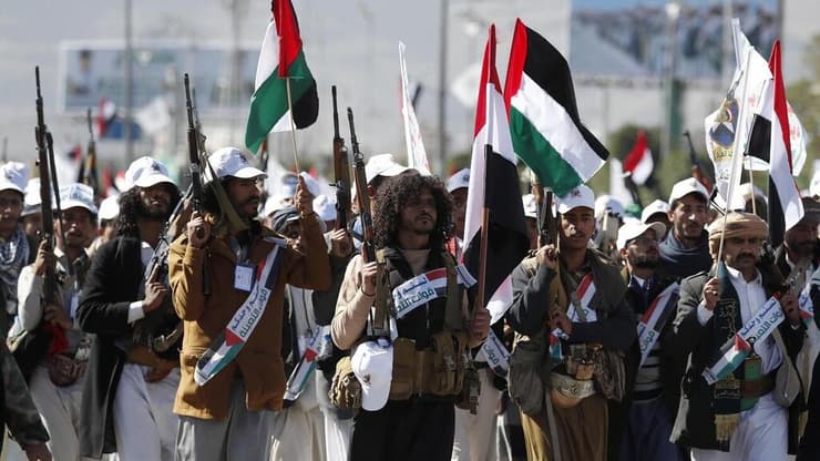 לוחמים חות'ים צועדים בצנעא עם דגלי פלסטין