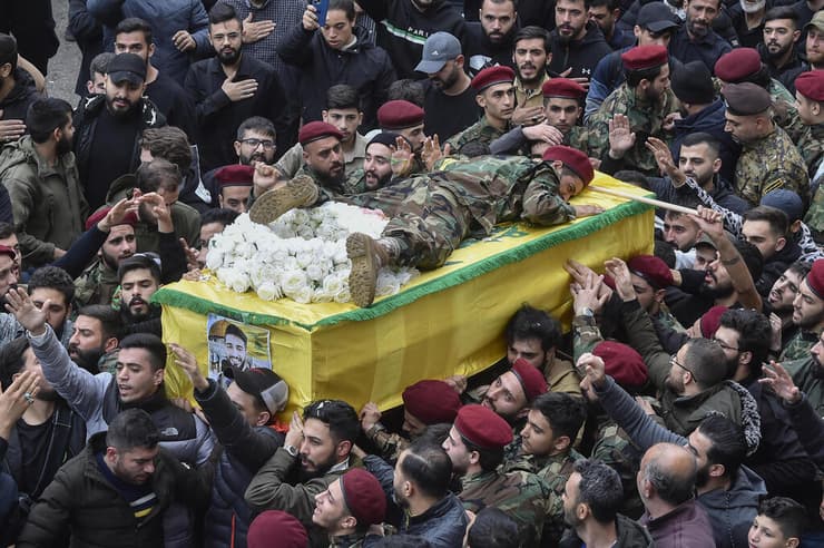 אחיו של מחבל חיזבאללה שנהרג נשכב על ארונו במהלך הלוויה ב ביירות לבנון