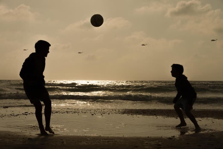 רן ואחיו משחקים בכדור בחוף הקשתות, הרצליה 