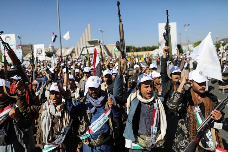 לוחמים חות'ים צועדים בצנעא עם דגלי פלסטין