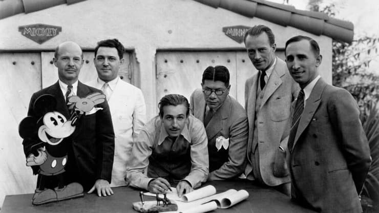 וולט דיסני (במרכז) ודמותו של מיקי מאוס, בשנת 1932