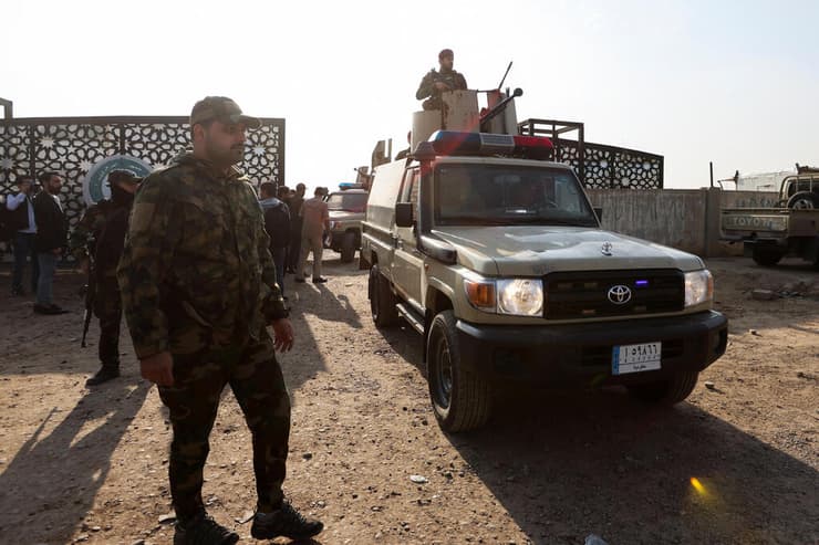 חמושים ב מיליציה מיליציות פרו-איראניות ליד  המטה שלהם ב בגדד עיראק שהופצץ