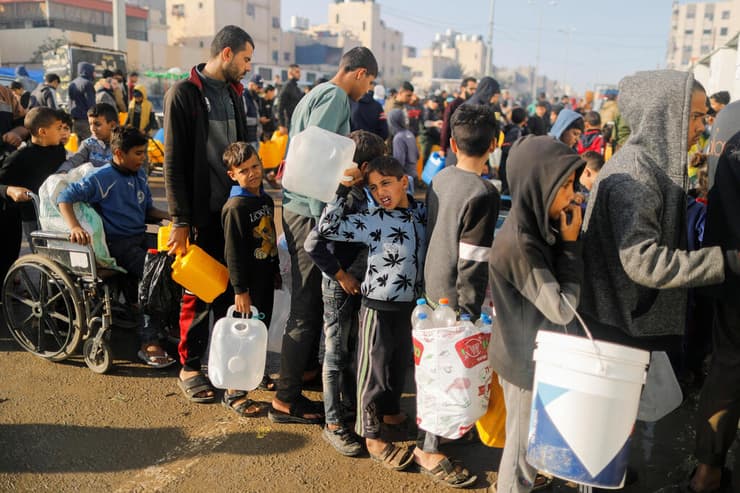 פליטים פלסטינים פליט מחכים עם בקבוקים  בתור ל מים ב רפיח רצועת עזה