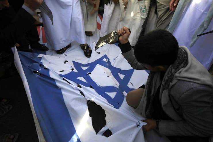 תימן צנעא תומכי חות'ים דוקרים את דגל ישראל