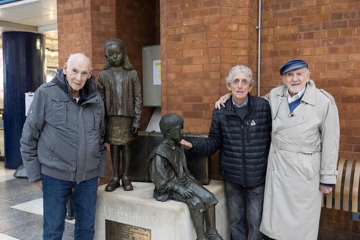 מימין לשמאל: וולטר בינגהם, פול אלכסנדר וג׳ורג׳ שפי באנדרטת הקינדרטרנספורט בתחנת ליברפול בלונדון 