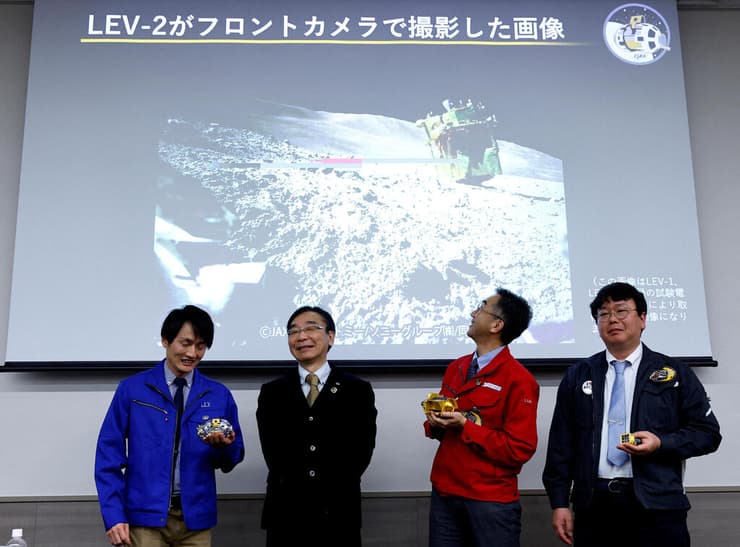 אנשי סוכנות החלל היפנית מסתכלים על תמונה של החללית