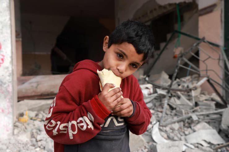 ילד פליט פליטים פלסטיני פלסטינים אוכל סנדוויץ' בצל דיווחים על רעב ב רצועת עזה