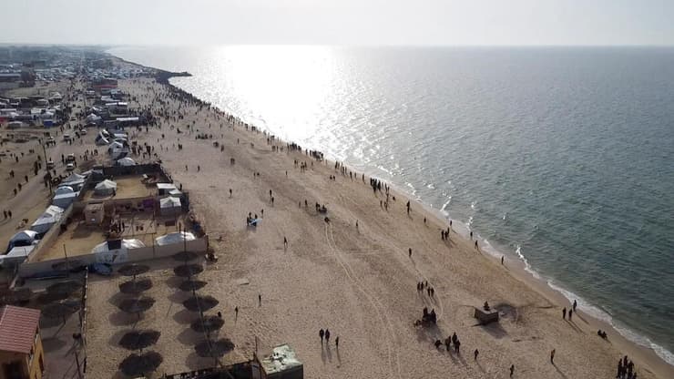 המוני פליטים ב דיר אל-בלח מצטופפים בחוף אחרי ש סיוע שהצניחה ירדן נפל בים