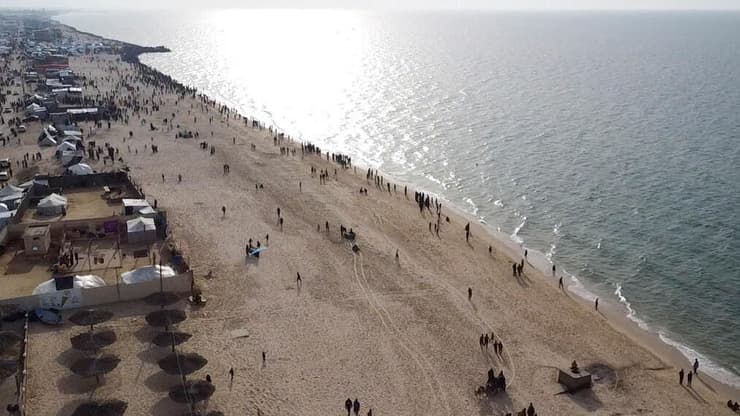 המוני פליטים ב דיר אל-בלח מצטופפים בחוף אחרי ש סיוע שהצניחה ירדן נפל בים