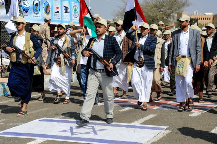 חייל חו'תי דורך על דגל ישראל בצעדה לתמיכה בפלסטינים