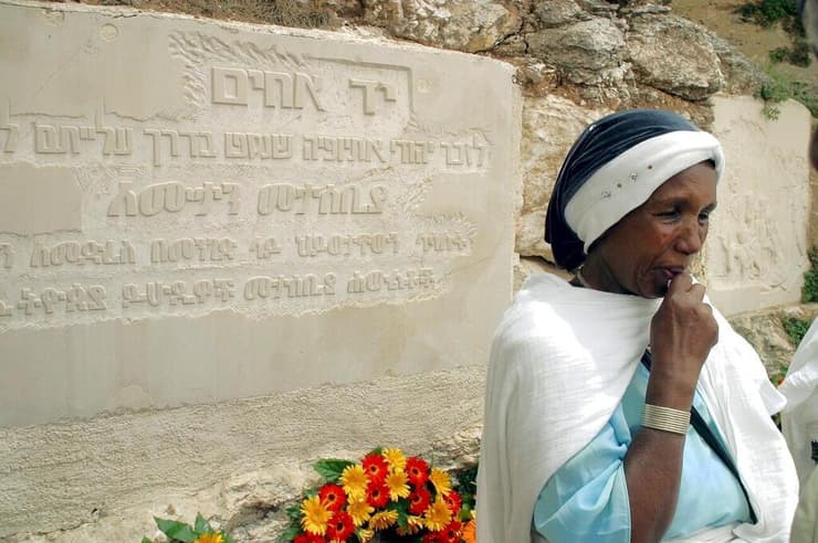 עולה מאתיופיה ליד אנדרטה לזכרם של יהודי אתיופיה שנהרגו במסעם לישראל
