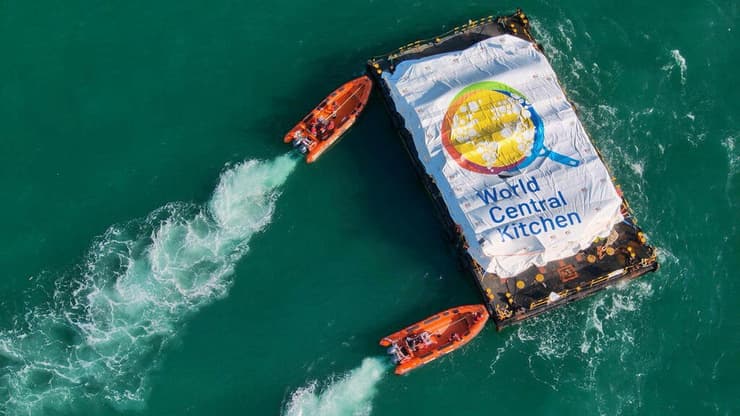 פריקת סיוע הומניטרי מזון שאסף ארגון World Central Kitchen מ דוברה שגררה ספינה של ארגון ספרדי בשם Open Arms ל חופי רצועת עזה אל רציף מאולתר