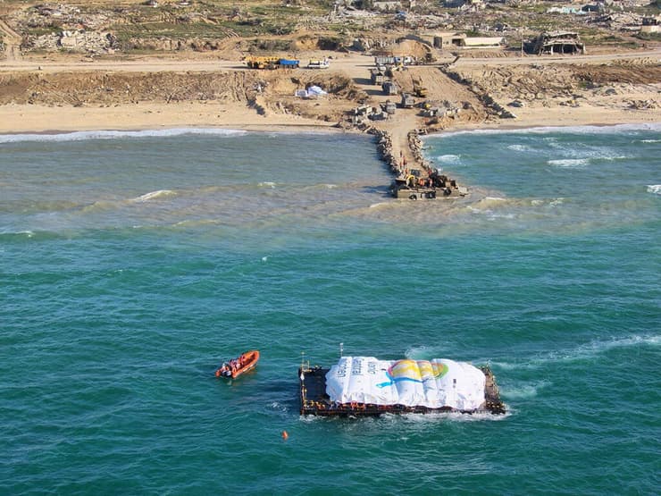 פריקת סיוע הומניטרי מזון שאסף ארגון World Central Kitchen מ דוברה שגררה ספינה של ארגון ספרדי בשם Open Arms ל חופי רצועת עזה אל רציף מאולתר