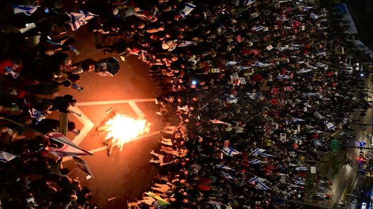 מפגינים מדליקים מדורה בשער בגין, קריה תל אביב
